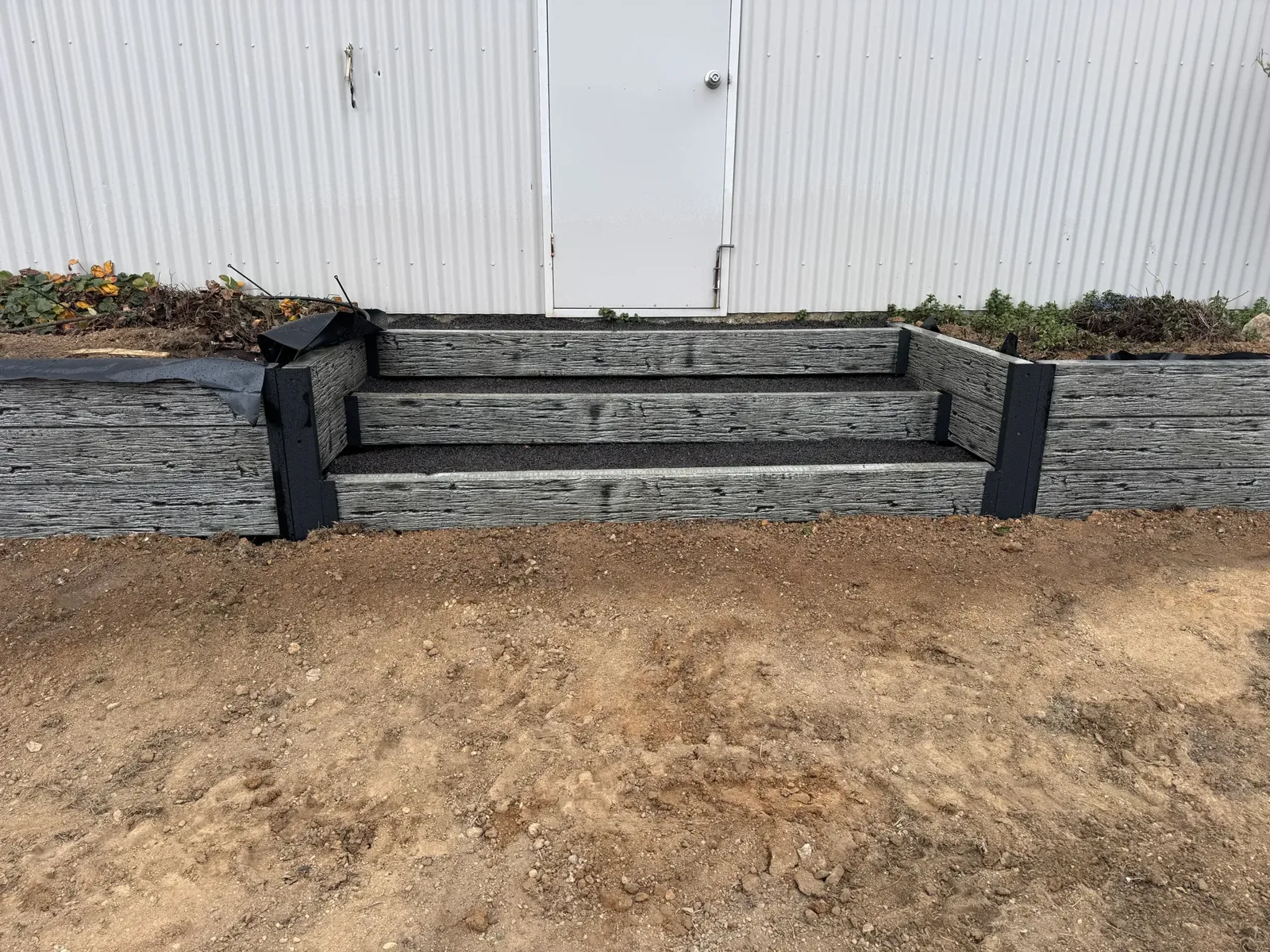 Timber sleeper retaining wall with steps