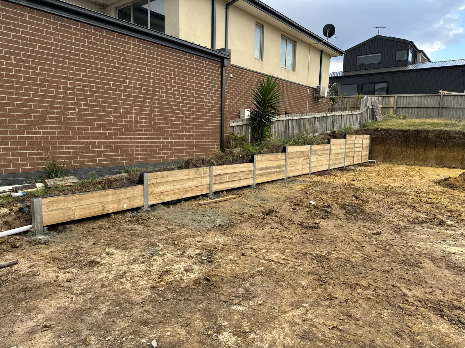 Timber sleeper retaining wall alongside home